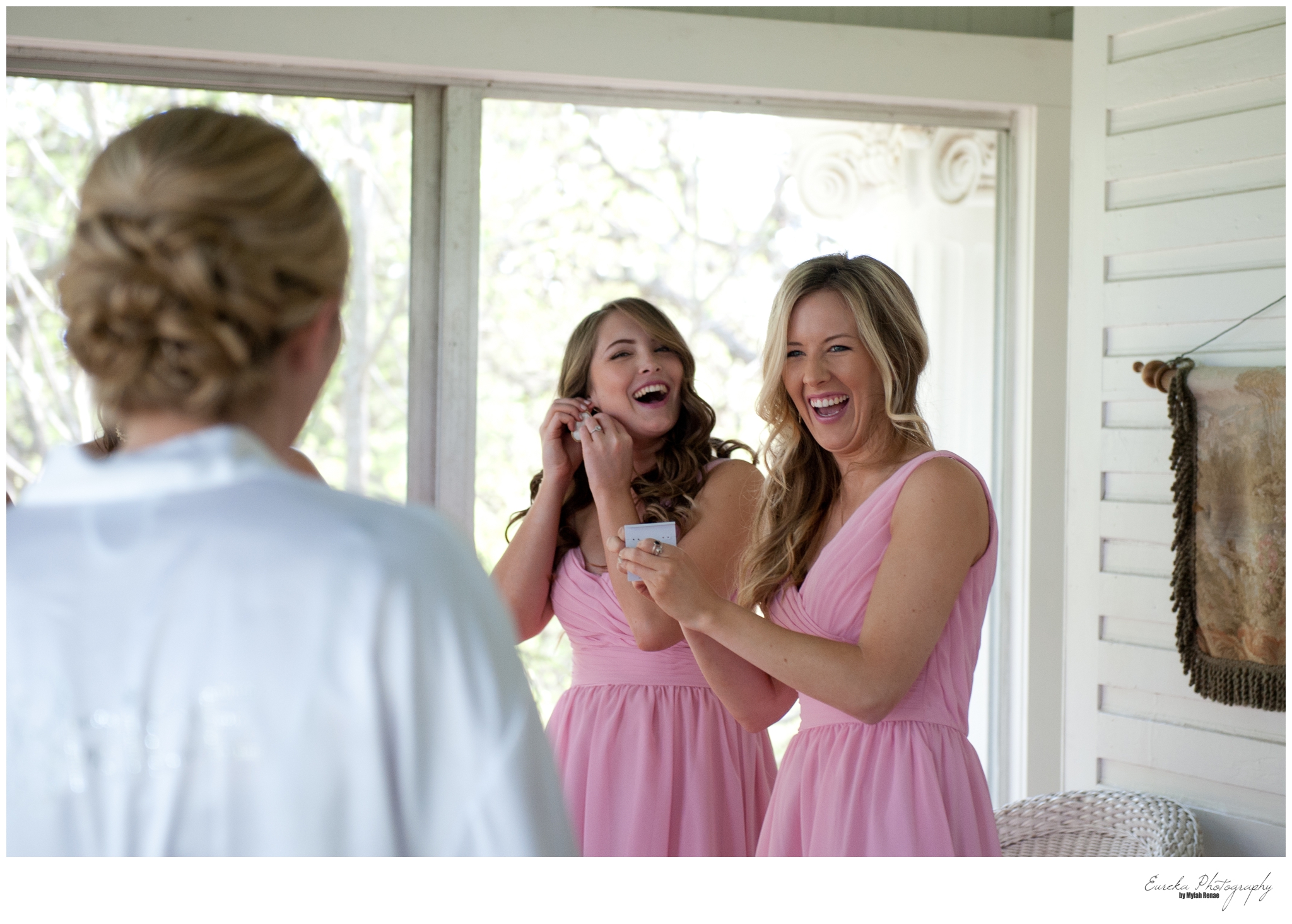 bridesmaids in pink react to gifts from the bride which was Kendra Scott earrings handpicked for each bridesmaid