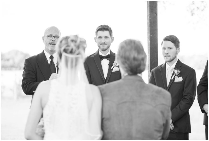 Groom smiles at bride and she is escorted down the aisle at Stonehouse Villa wedding ceremony
