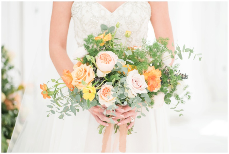 Bride holds orange and blush wedding bouquet at White Sparrow Barn Wedding