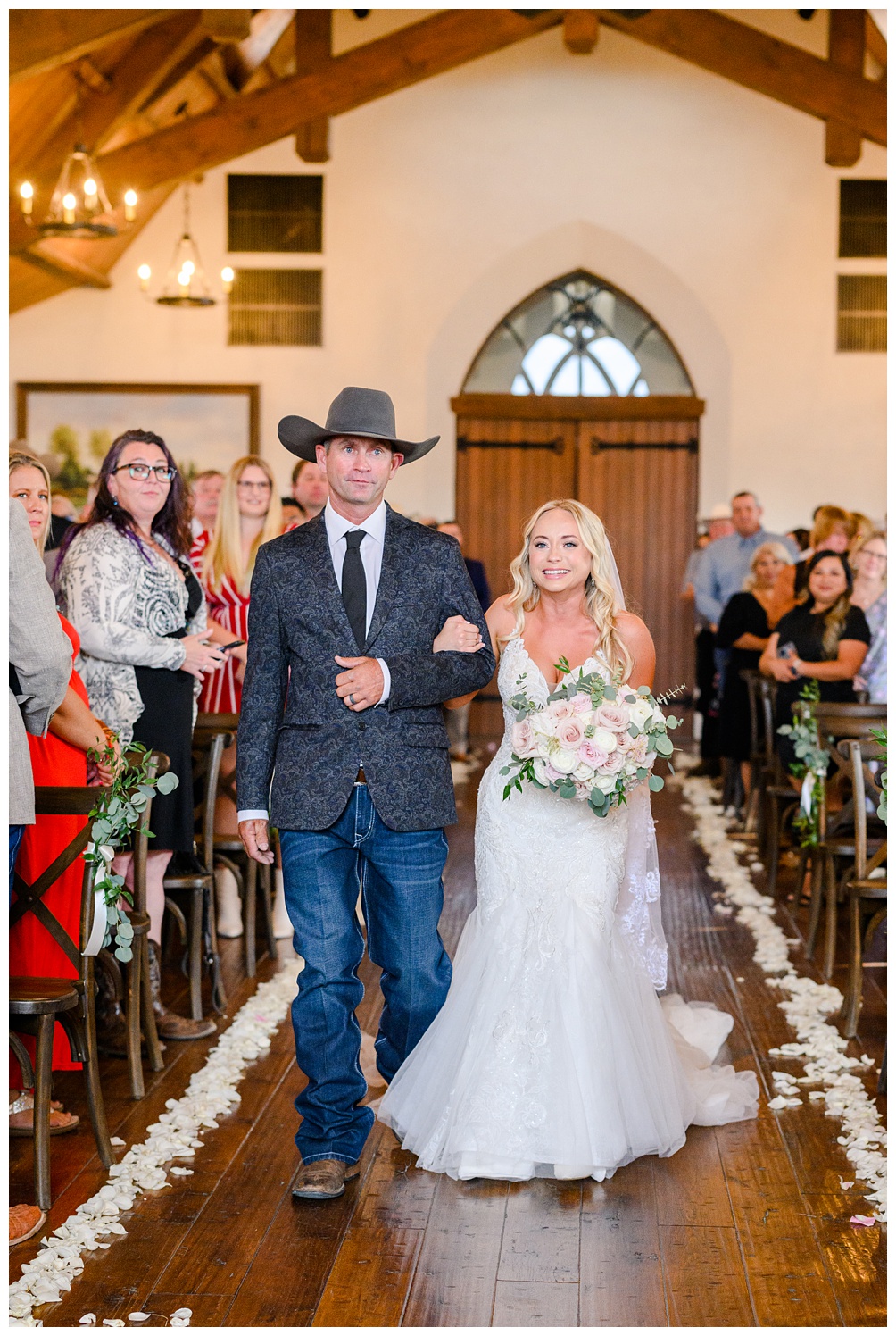 Bride walks down the aisle at indoor wedding ceremony at Hidden River Ranch