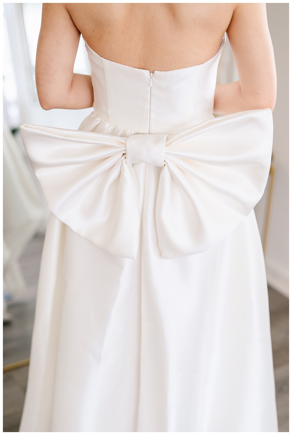 Close-up of a strapless satin wedding dress featuring a dramatic oversized bow at the back, captured during a modern bridal portrait session in Austin.