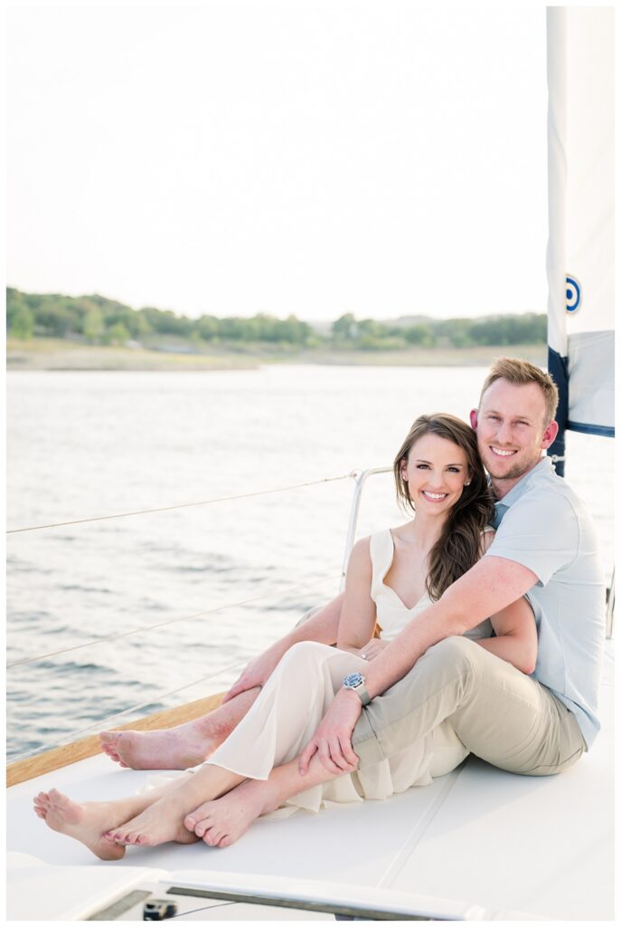 couple sitting on sailboat edge Lake Travis engagement session